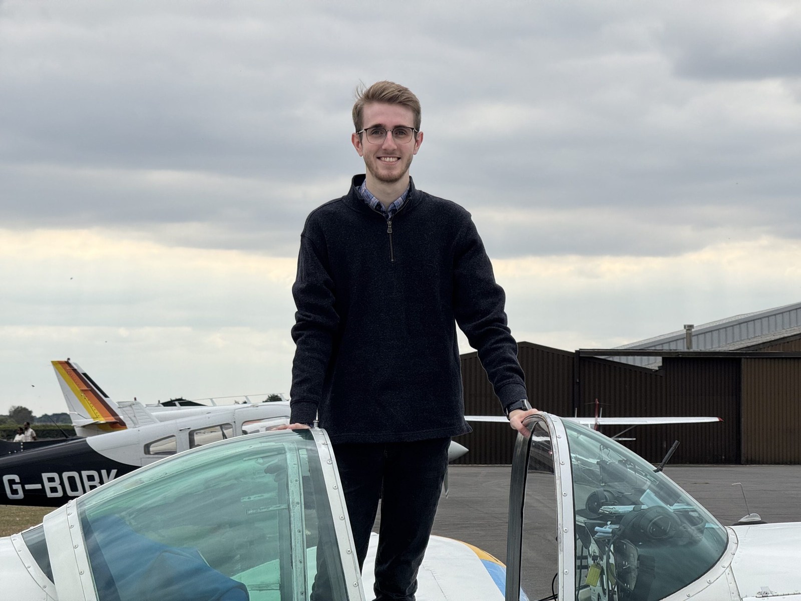 Harrison Grose standing beside a light aircraft