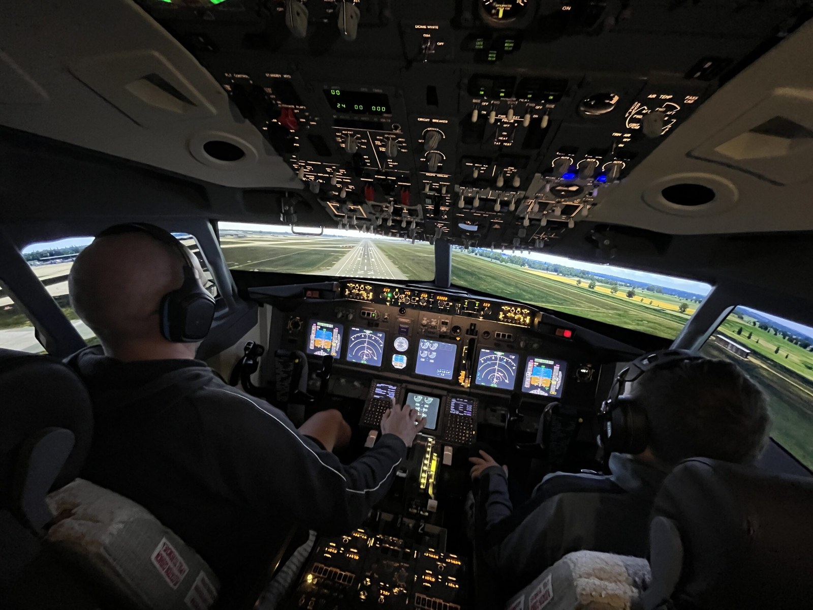 An instructor helping a visitor fly the simulator